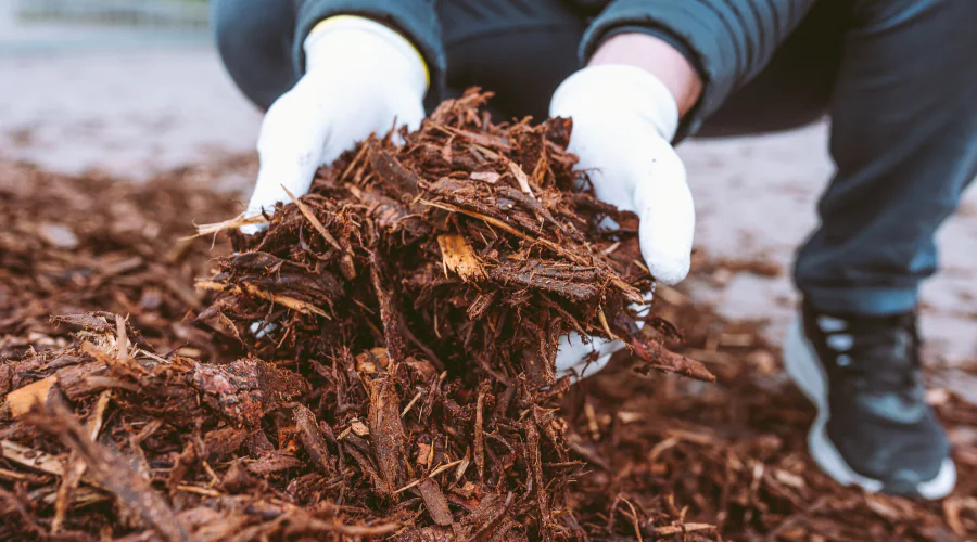 A gardener working with a pile of organic mulch in Lancaster, PA.