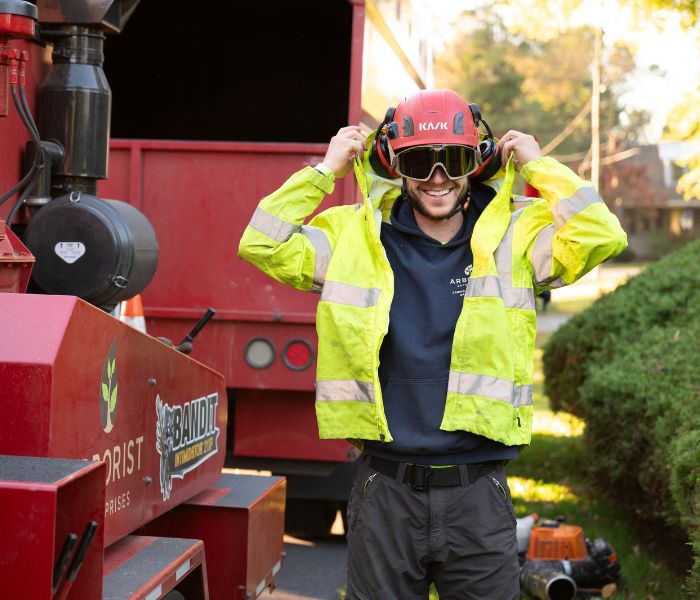 Arborist smiling while putting on his safety gear.