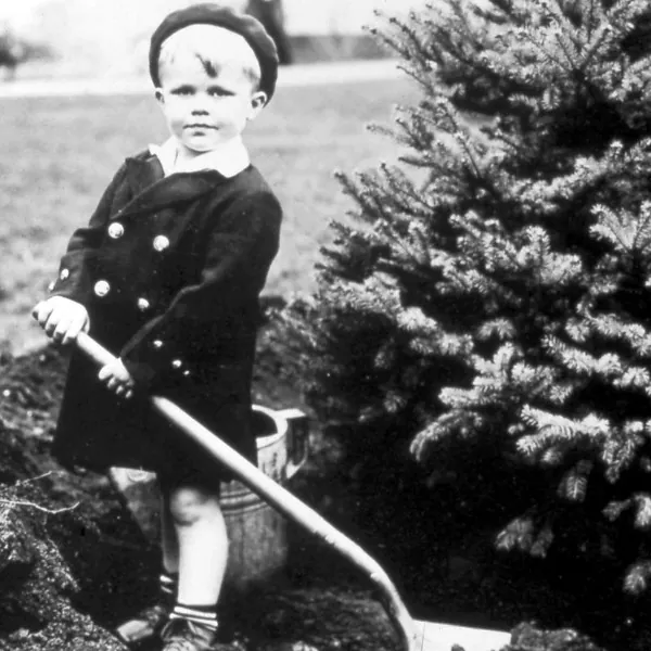An old photo of a kid planting a tree during Arbor Day in PA